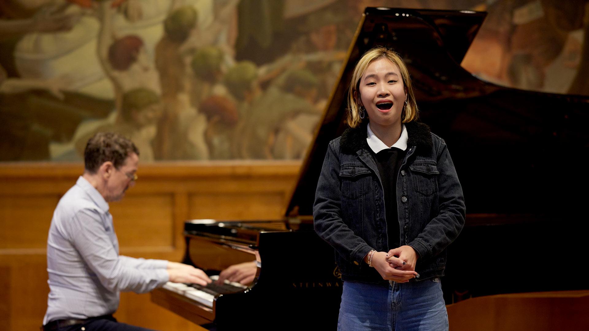 female singer performing in front of a pianist